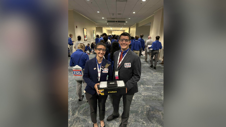 a man and woman stand together at a conference