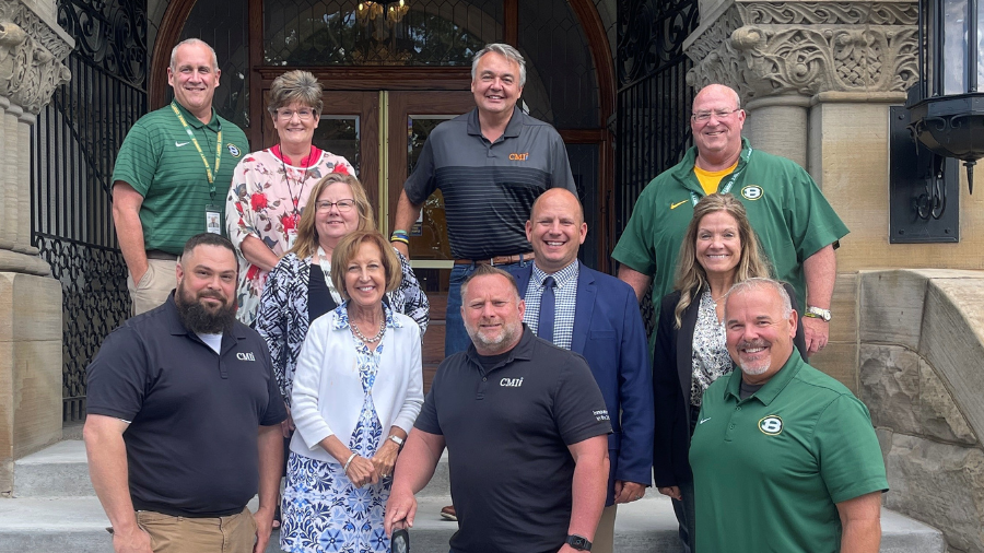 Group of men and women stand smiling