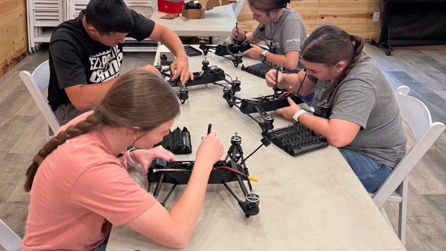 Individuals using tools to build drones